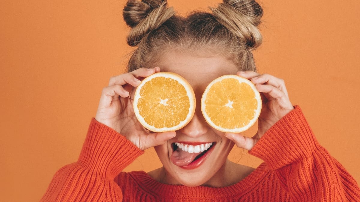 Jeune femme avec deux moitiés d'orange sur les yeux - huiles essentielles